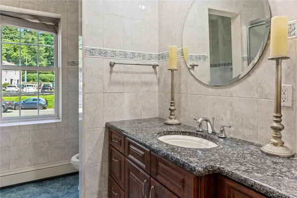 a bathroom with a granite countertop sink and a mirror