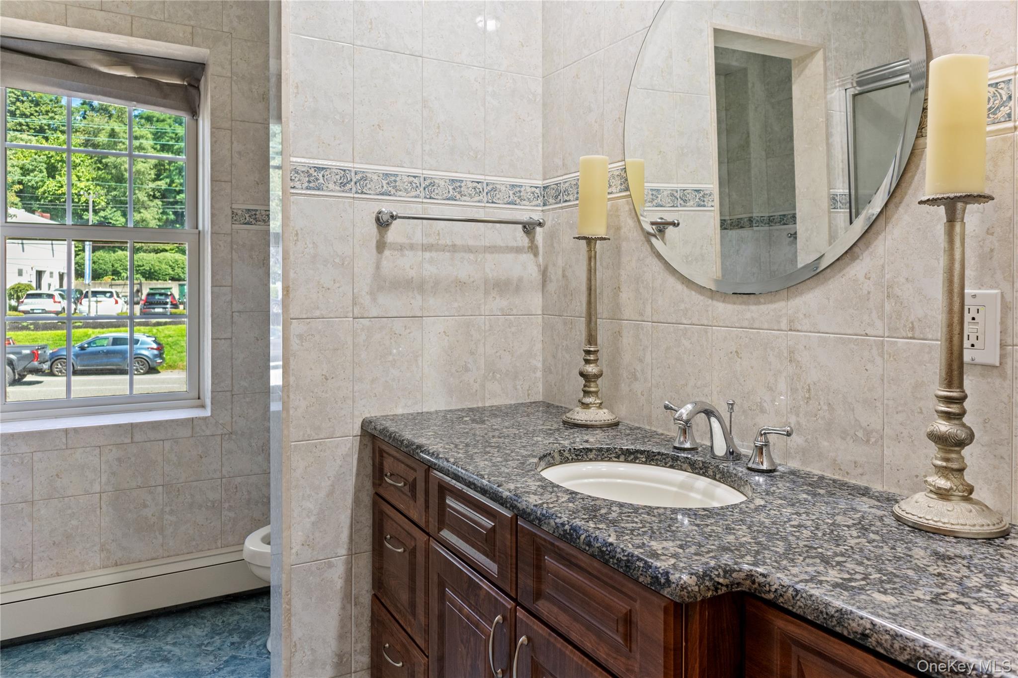72 Cedar Swamp Road, Unit 3 Glen Cove, NY 11542 - Photo 5 of 10 a bathroom with a granite countertop sink and a mirror