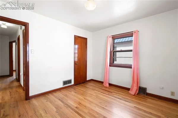 a view of empty room with wooden floor