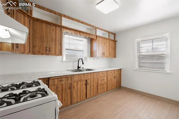 a kitchen with a sink a stove and cabinets