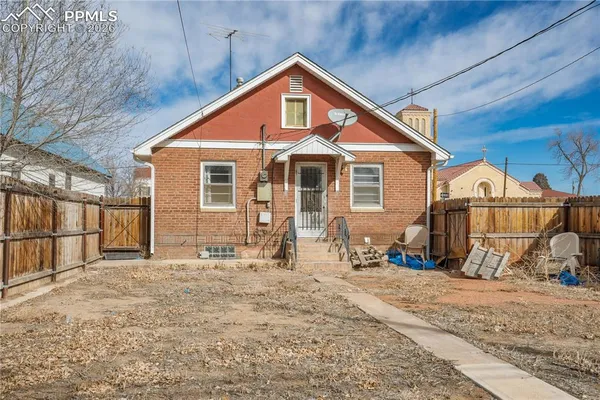 a view of a house with wooden fence