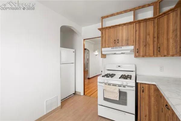 a kitchen with white cabinets and white appliances