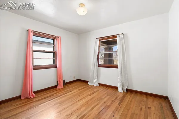 an empty room with wooden floor and closet