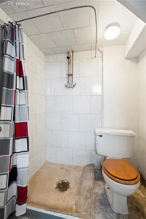 a bathroom with a toilet and a shower