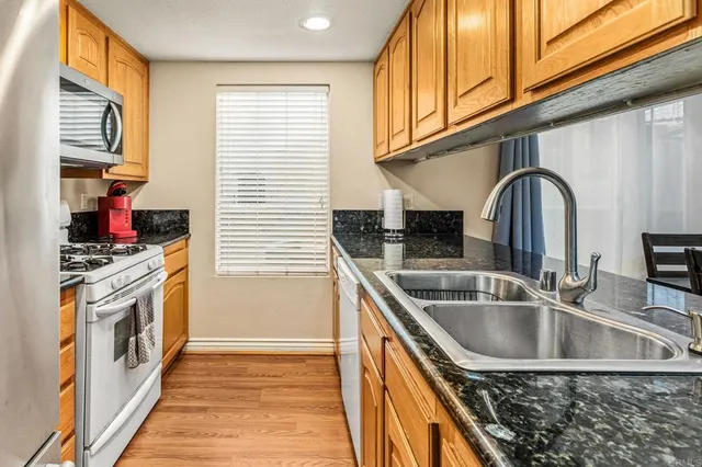a kitchen with kitchen island a sink a stove cabinets and a window