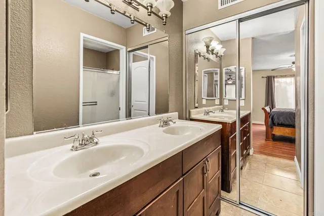 a en suite bathroom with a granite countertop sink and a mirror
