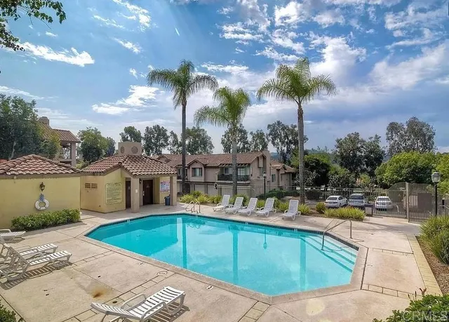 a view of a swimming pool with a yard and plants