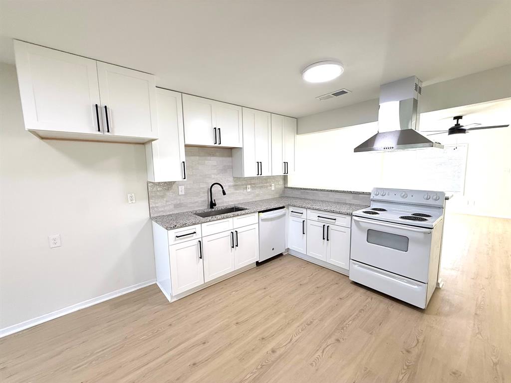 1401 Arvel Circle Azle, TX 76020 - Photo 1 of 26 a white kitchen with wooden floor and white stainless steel appliances
