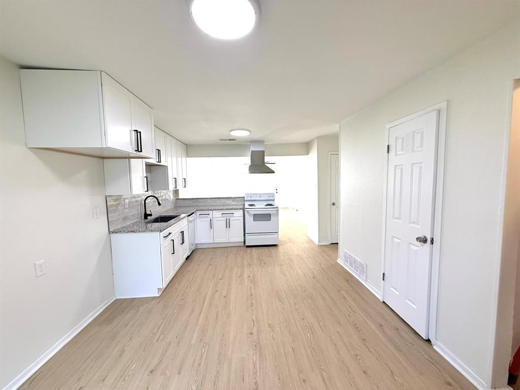 1401 Arvel Circle Azle, TX 76020 - Photo 3 of 26 a large kitchen with a wooden floor and stainless steel appliances