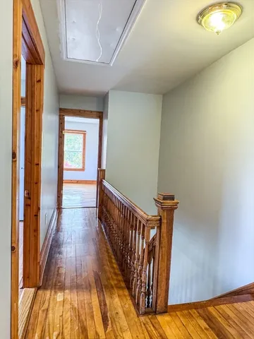a view of a hallway with wooden floor and staircase