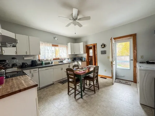 a kitchen with a table chairs refrigerator and cabinets