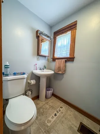 a bathroom with a sink toilet and a window