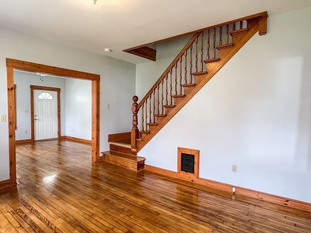 a view of staircase with white walls and wooden floor