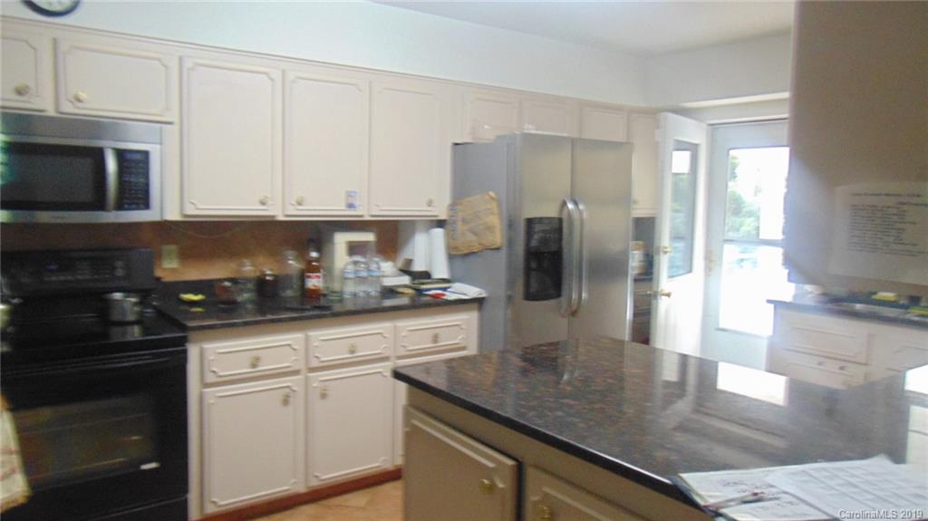 3516 Brevard Road Hendersonville, NC 28791 - Photo 19 of 20 a kitchen with stainless steel appliances granite countertop a refrigerator a stove a sink and white cabinets