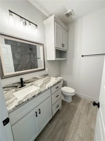 a view of a hallway with entryway wooden floor and cabinet