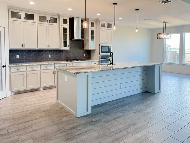 a kitchen with stainless steel appliances granite countertop a sink a stove and a refrigerator