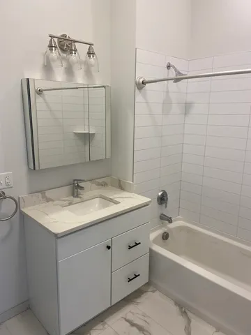 a bathroom with a granite countertop sink a mirror and shower