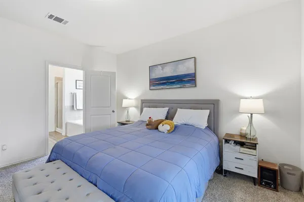 a bedroom with a bed and a lamp on table