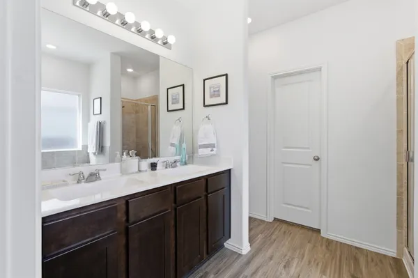 a bathroom with a double vanity sink mirror and shower