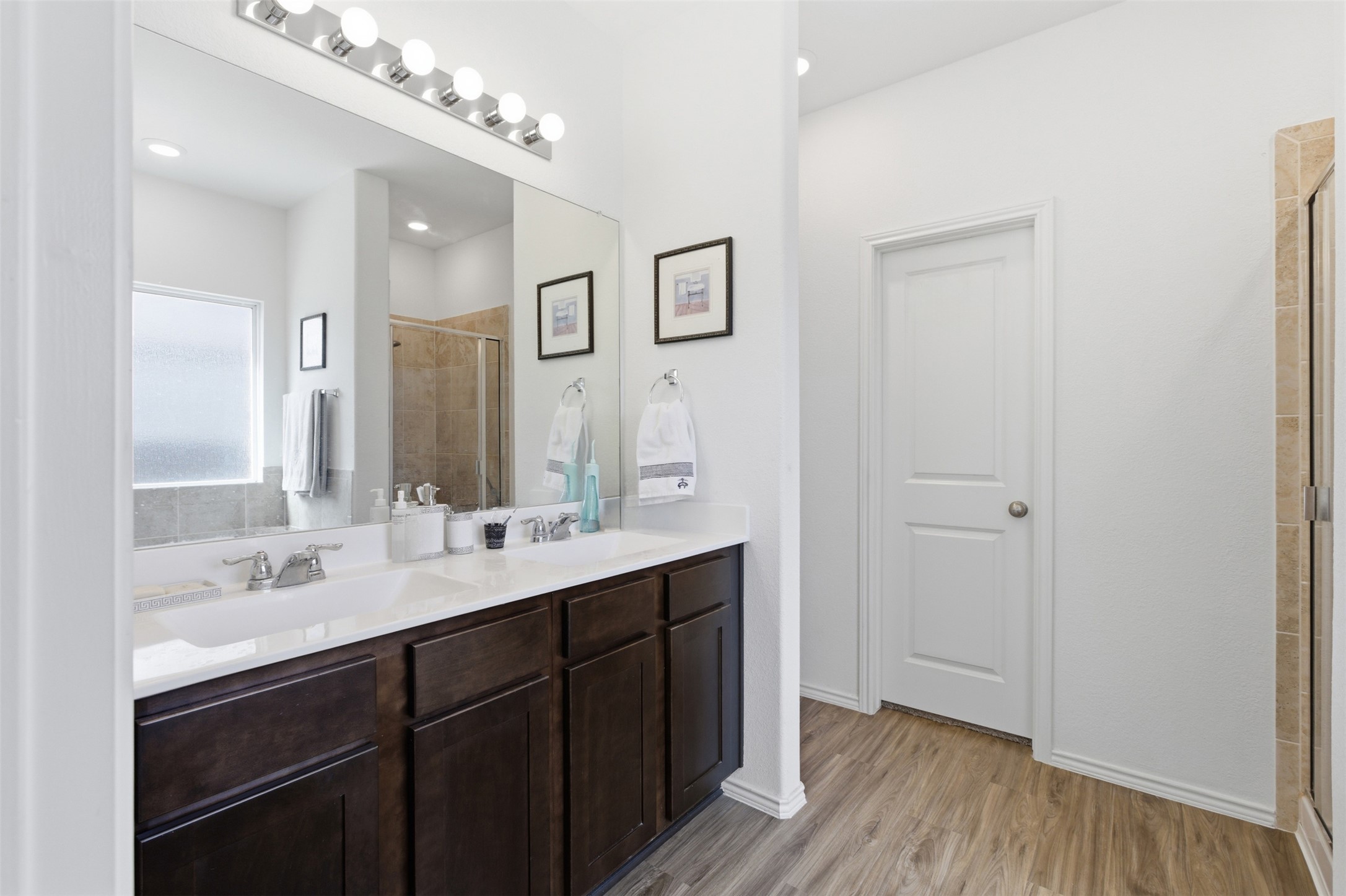 832 Mallow Road Leander, TX 78641 - Photo 13 of 29 Full bathroom featuring double vanity, a shower stall, and light wood-style flooring