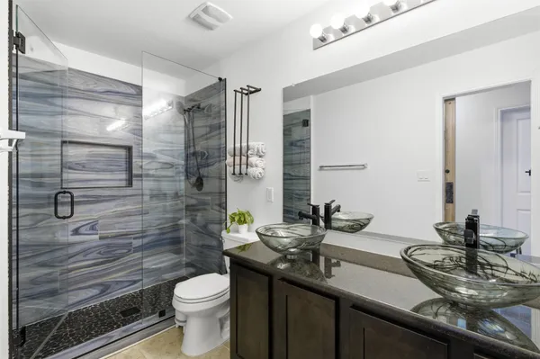 a bathroom with a sink a toilet and shower