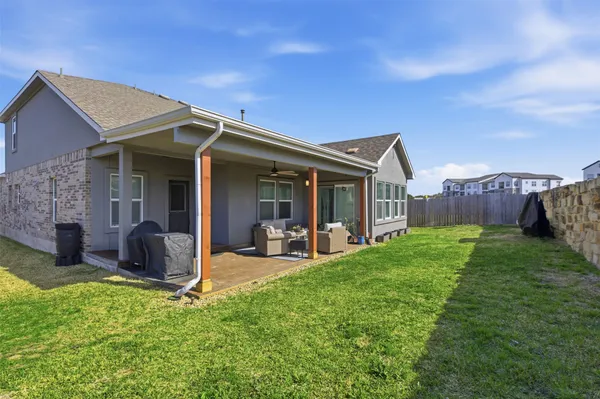 a view of a house with backyard porch and furniture