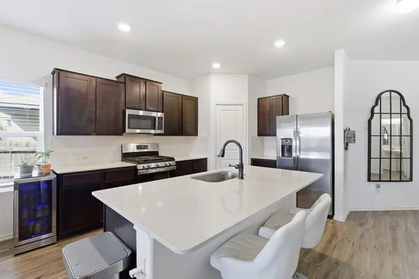 a kitchen with granite countertop a sink a counter space appliances and cabinets