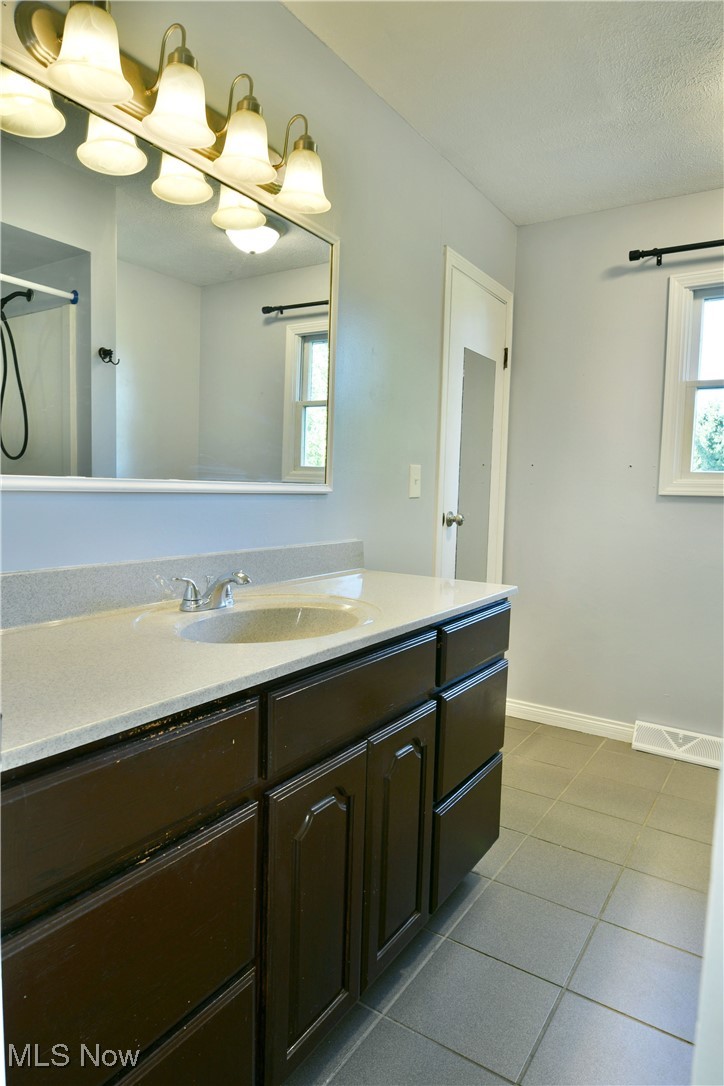4461 Ridge Road Cortland, OH 44410 - Photo 22 of 47 Bathroom featuring tile patterned flooring, walk in shower, vanity, and a textured ceiling