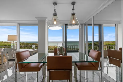 a living room with furniture wooden floor dining table and a large window