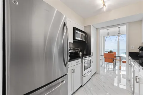 a kitchen with granite countertop a sink dishwasher stove and cabinets