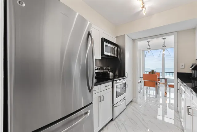 a kitchen with granite countertop a sink dishwasher stove and cabinets