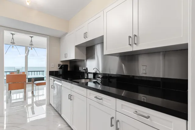 a kitchen with stainless steel appliances granite countertop a refrigerator a sink a stove and cabinets