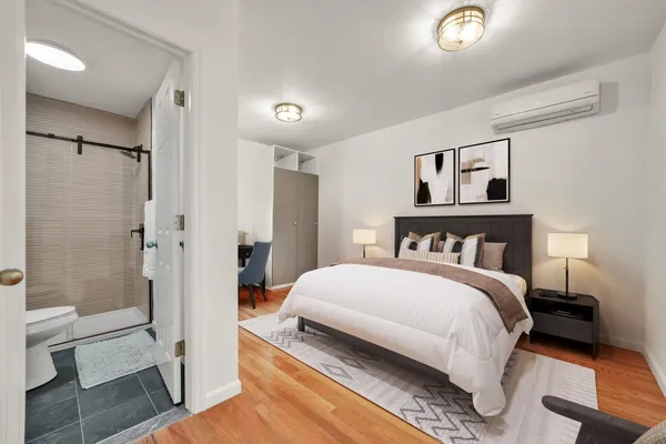 a bedroom with a bed and a glass door shower