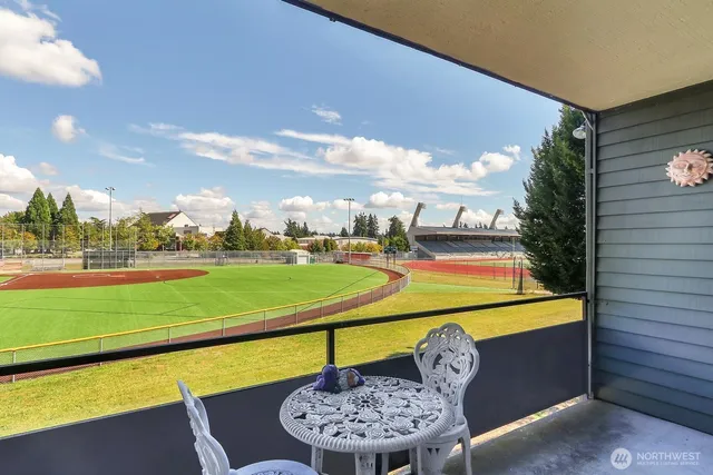 a view of a swimming pool with a chairs and table in the patio