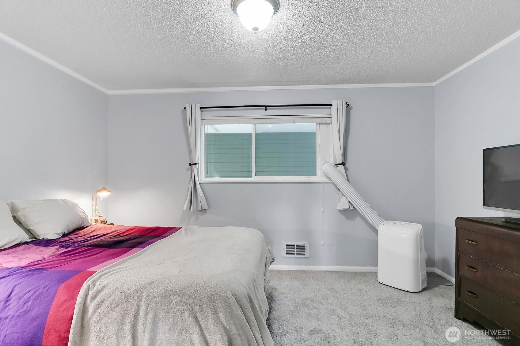 7924 212th Street Southwest, Unit 211 Edmonds, WA 98026 - Photo 13 of 14 a bedroom with a bed and a tv