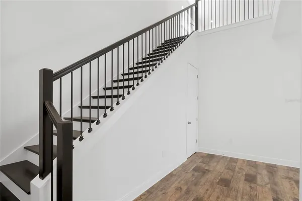 a view of staircase with wooden floor and white walls