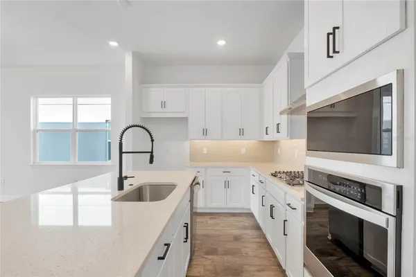 a kitchen with stainless steel appliances granite countertop a sink and stove top oven