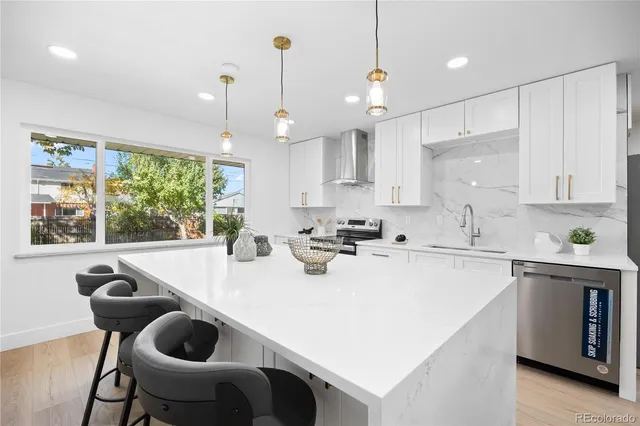 a kitchen with a stove a refrigerator a sink a dining table and chairs