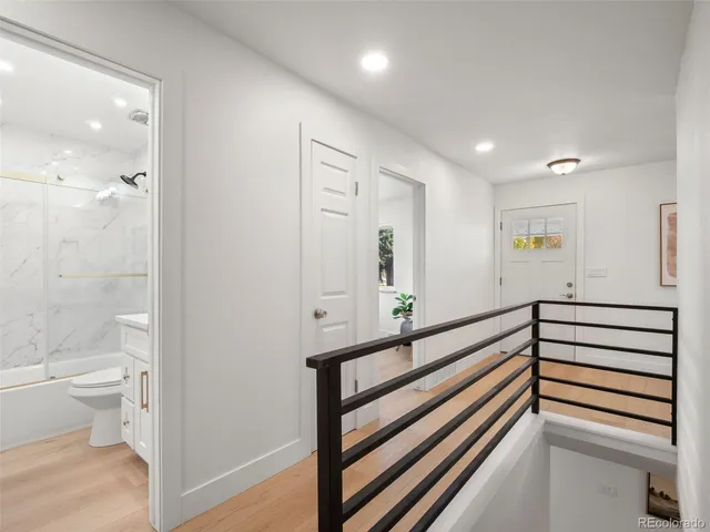 a view of a hallway with toilet and a sink