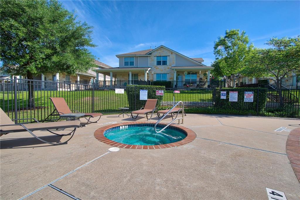 1900 Scofield Ridge Parkway, Unit 5501 Austin, TX 78727 - Photo 17 of 21 An inviting hot tub area with chaise lounge seating awaits for relaxation, set against a backdrop of residential buildings.