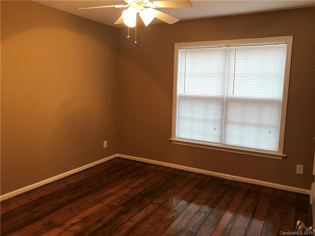 5815 Faith Road Salisbury, NC 28146 - Photo 8 of 16 an empty room with wooden floor and windows