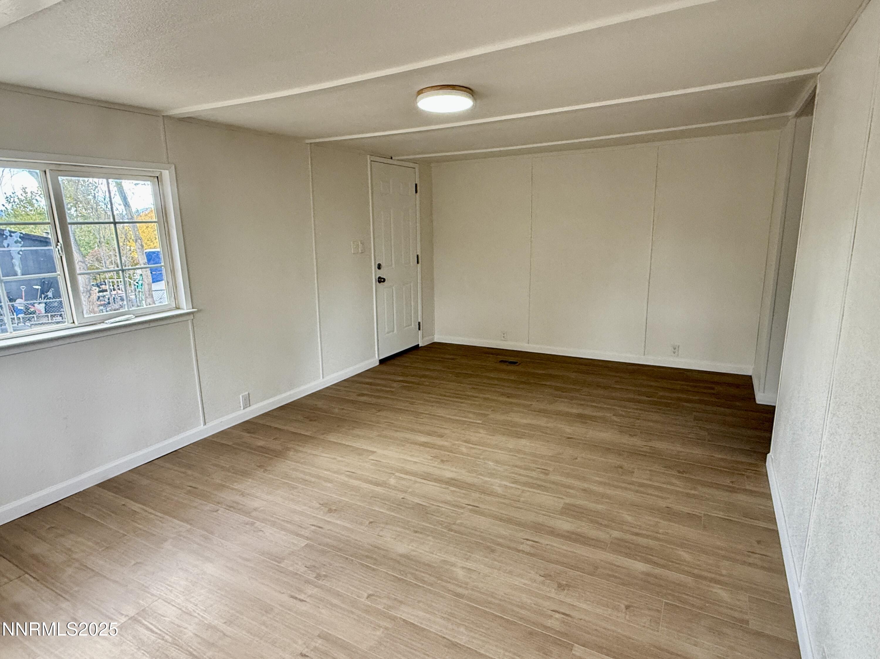 3855 Sandpiper Drive Reno, NV 89508 - Photo 6 of 28 a view of an empty room with window and wooden floor