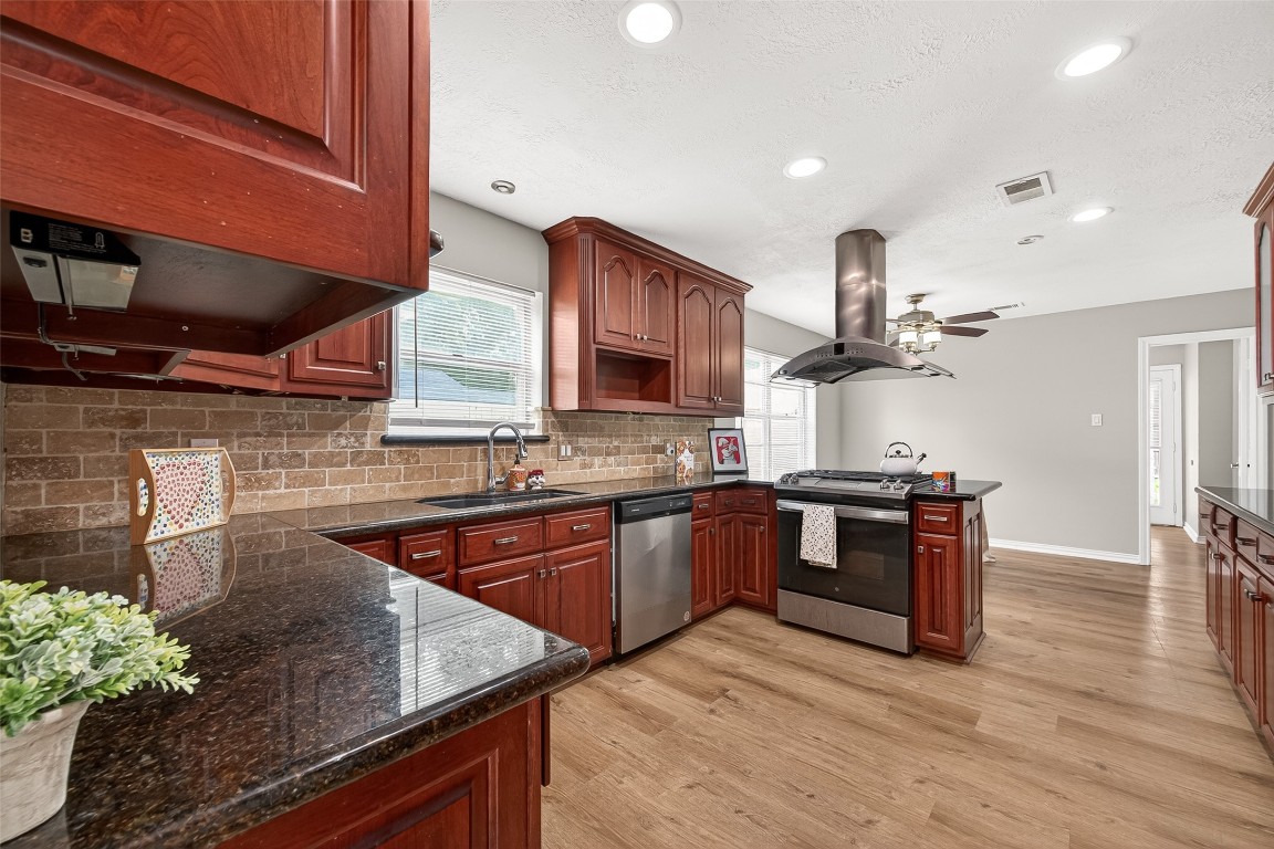 4230 Annawood Circle Spring, TX 77388 - Photo 31 of 50 a kitchen with stainless steel appliances granite countertop a sink a stove and a wooden floors