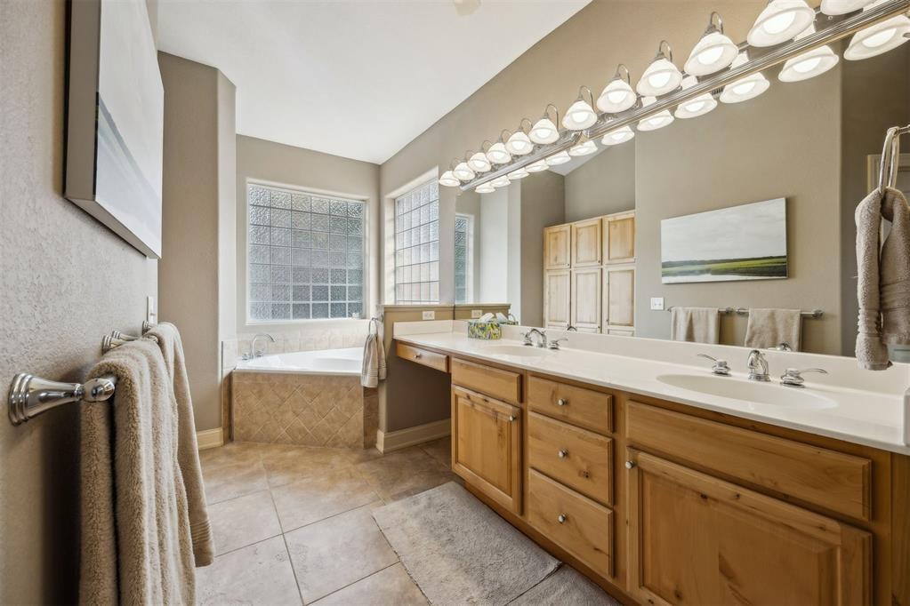 96022 Heath Point Lane Fernandina Beach, FL 32034 - Photo 22 of 39 a spacious bathroom with a granite countertop sink a large mirror and a bathtub