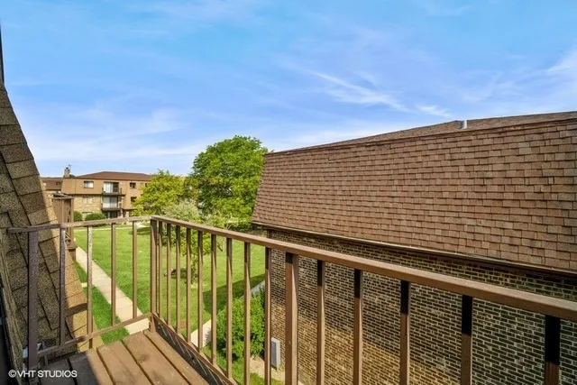 a view of a balcony with wooden floor and fence