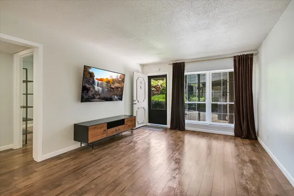 a view of a livingroom with wooden floor and furniture