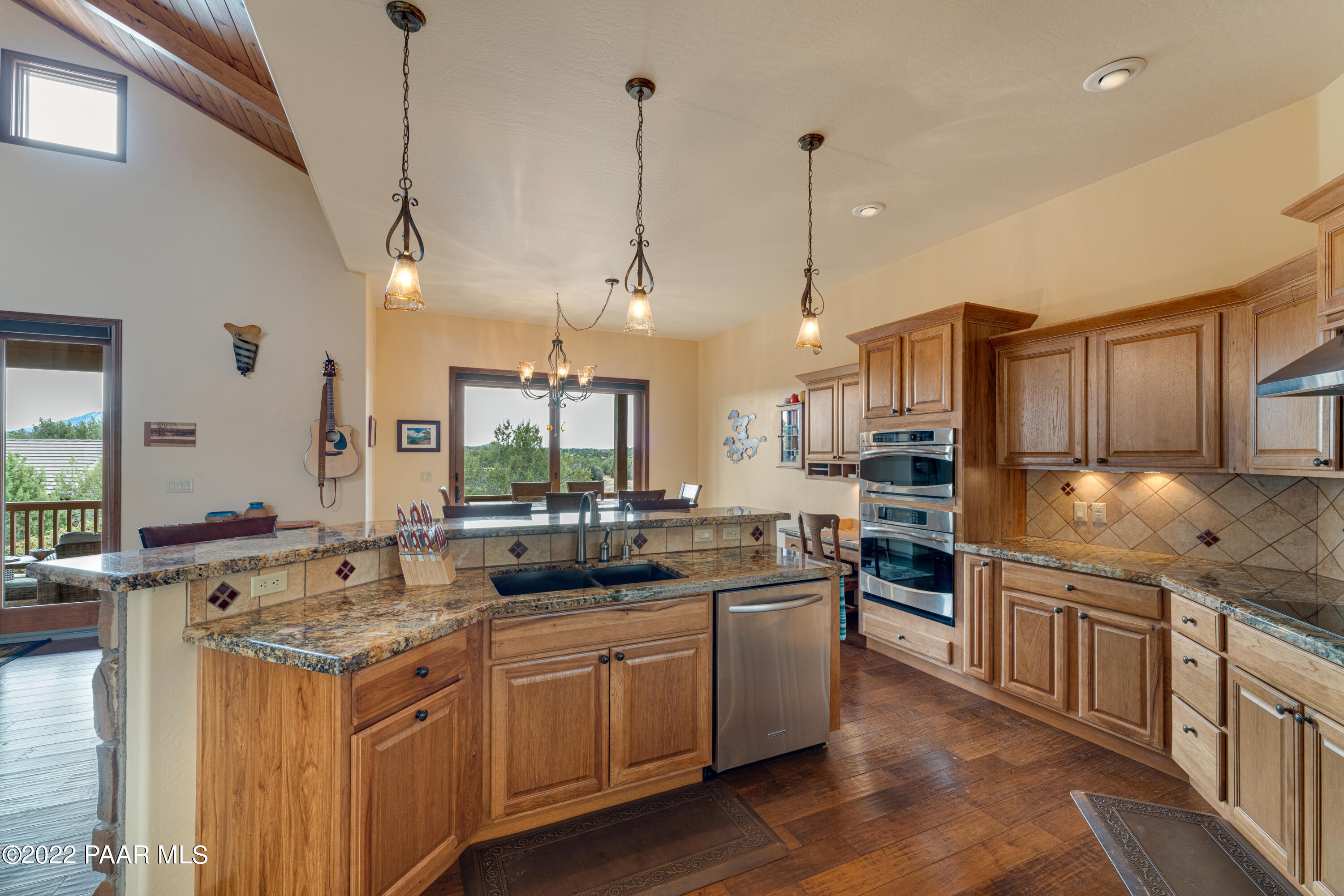 5695 West Three Forks Road Prescott, AZ 86305 - Photo 14 of 48 a kitchen with stainless steel appliances granite countertop a sink a stove and a wooden floors
