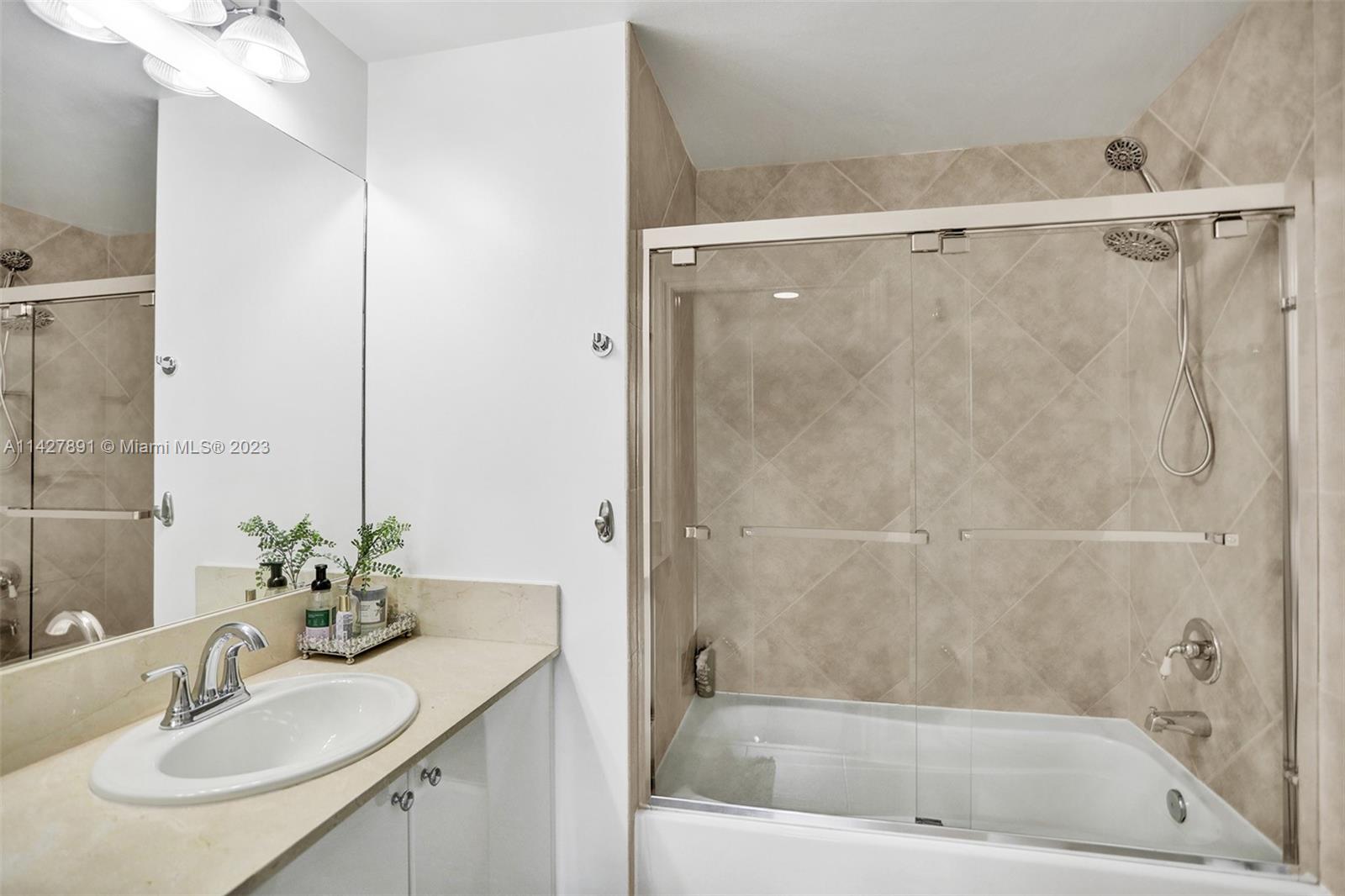 233 South Federal Highway, Unit 605 Boca Raton, FL 33432 - Photo 29 of 41 a bathroom with a granite countertop sink a mirror and a bathtub