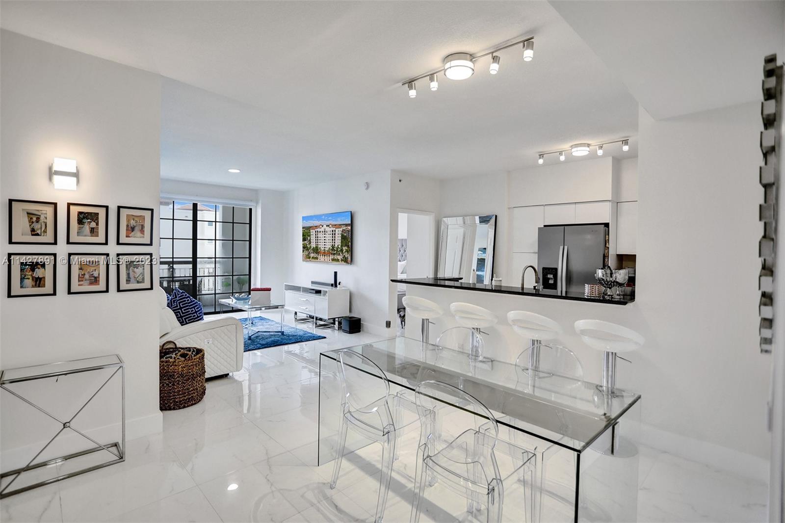 233 South Federal Highway, Unit 605 Boca Raton, FL 33432 - Photo 35 of 41 a living room with furniture a chandelier and kitchen view