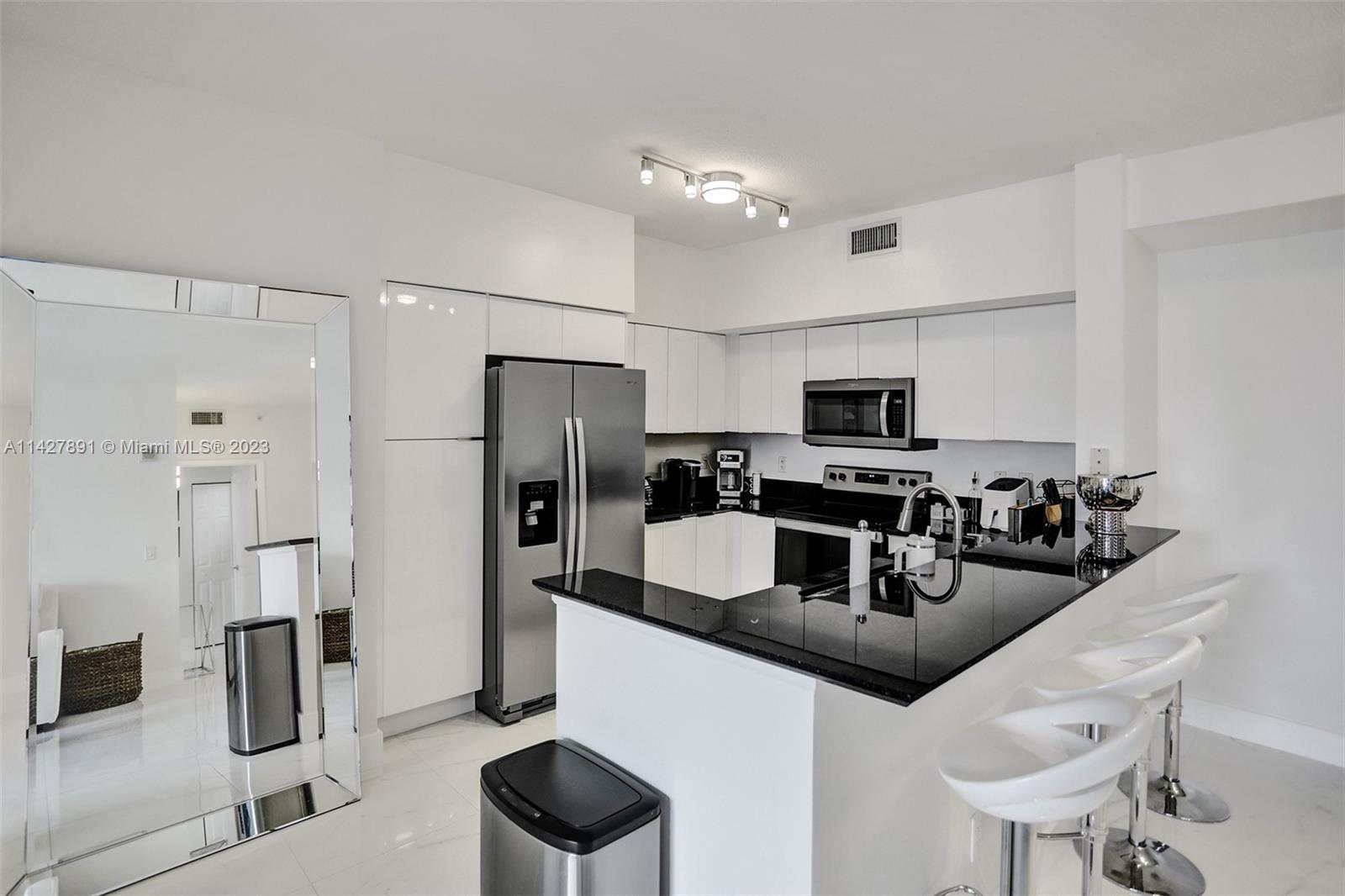 233 South Federal Highway, Unit 605 Boca Raton, FL 33432 - Photo 8 of 41 a kitchen with stainless steel appliances granite countertop a sink refrigerator and microwave
